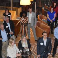 Alumni at the reception, watching T.Haas present his speech